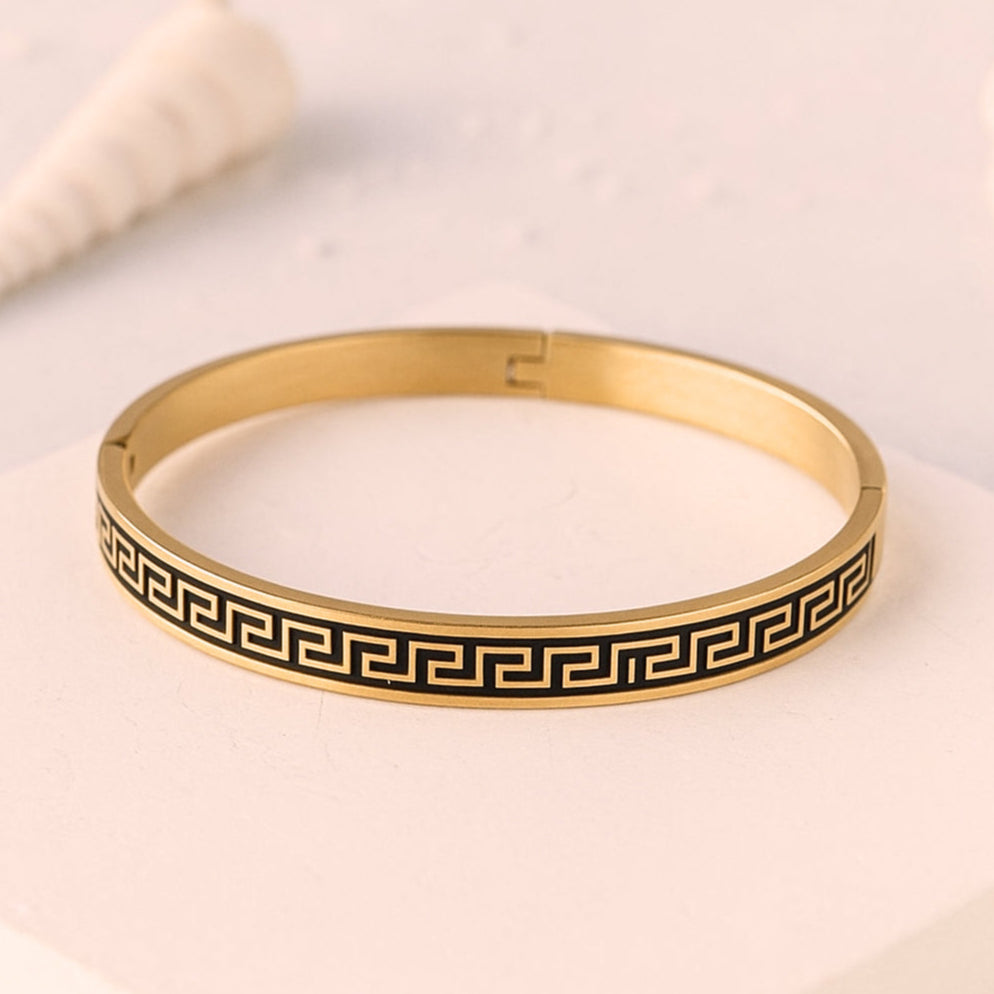 Gold bracelet with black pattern on a light background, featuring the ZAR brand.