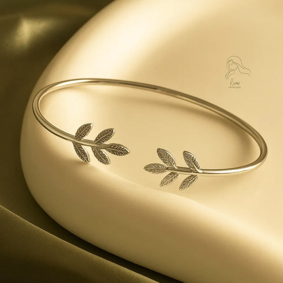 Gold bracelet with leaf designs on a gold surface, featuring the ZAR brand.
