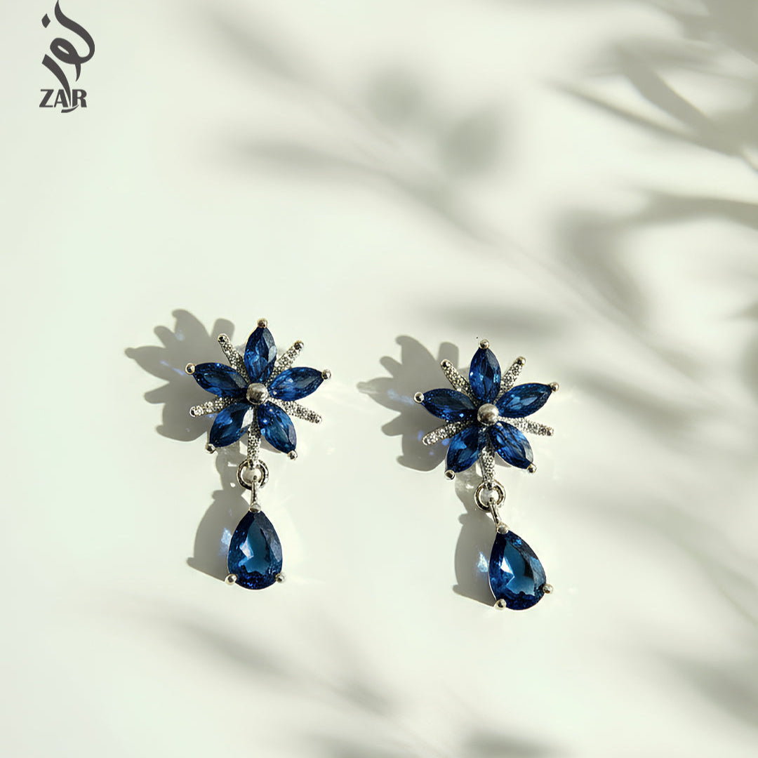 Blue gemstone earrings on a white background with ZAR branding.
