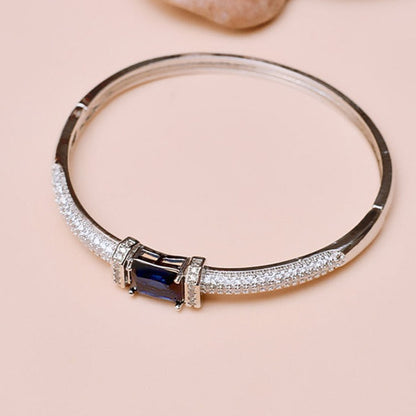 Silver bracelet with a blue gemstone on a beige background