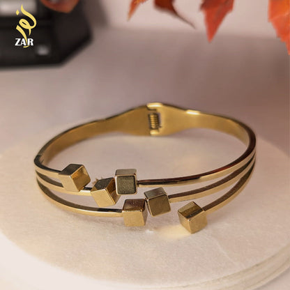 Gold bracelet with geometric design on a light background