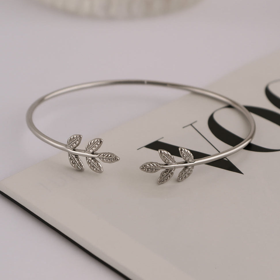 Silver bangle with leaf designs on a magazine