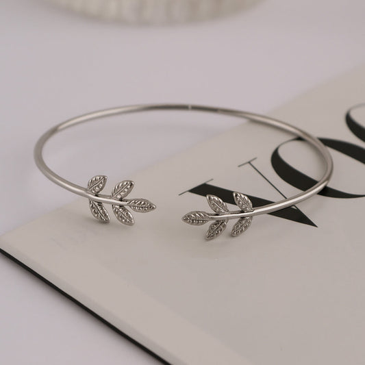 Silver bangle with leaf designs on a magazine