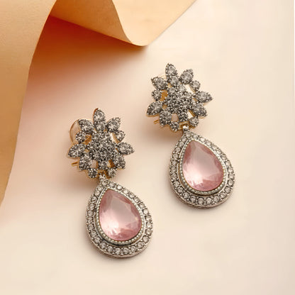 Ornate earrings with pink teardrop stones on a beige background, featuring the brand 'ZAR'.