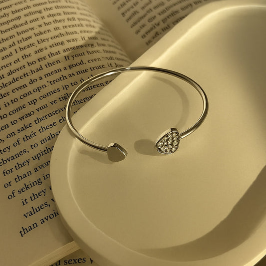 Silver bracelet with heart details on an open book