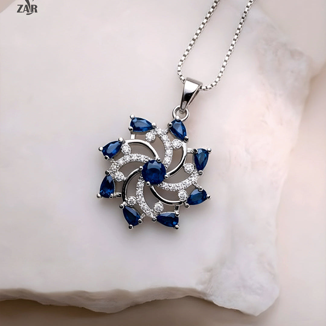 Silver pendant with blue gemstones on a white background