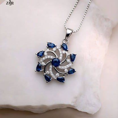 Silver pendant with blue gemstones on a white background